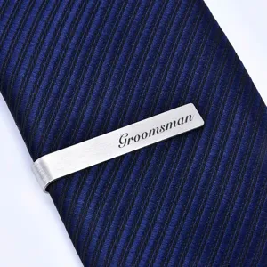 Stainless steel tie clip detail showing brushed metal finish and custom groomsman engraving.