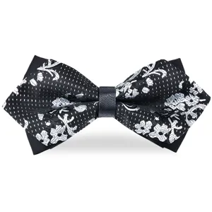 Detailed close-up of a black and white floral pointed bow tie with elegant woven texture.