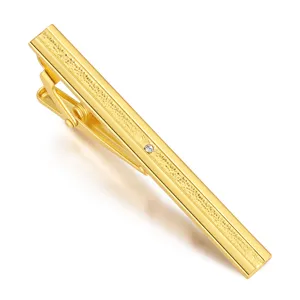 Pince à cravate dorée pour homme avec bande texturée et accent de cristal étincelant.