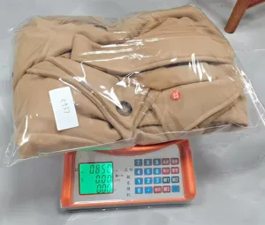 Thick woolen women coat detail view showing packaging and weight measurement in warehouse.