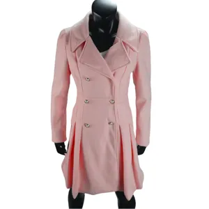 Dettaglio in primo piano del cappotto lungo in lana rosa con bottoni e orlo plissettato.