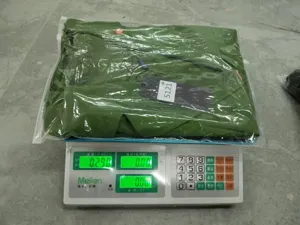 Vue détaillée de haut blazer pour femme vert, emballé sur balance électronique.
