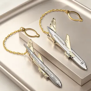 Gros plan sur la pince a cravate en metal argente et dore en forme d'avion homme.