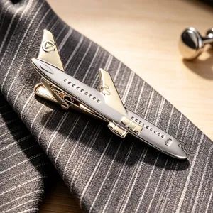 Élégante pince à cravate forme avion en métal doré et argenté pour homme chic.
