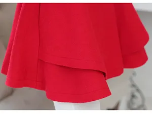 Primer plano detallado del dobladillo del abrigo de lana roja, diseño de vuelo en capas.