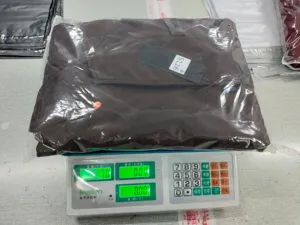 Detailaufnahme eines verpackten Herren Freizeitanzugs auf einer digitalen Waage im Lager