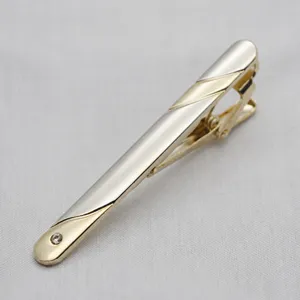 Detailed view of elegant gold and silver metal tie clip with sparkling rhinestone decor.