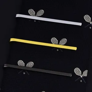 Gros plan de pinces à cravate métalliques fines en argent, or et noir pour hommes.