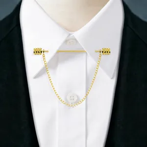 Close-up detail of gold collar pin with chain, elegant metal accessory for men shirt decor.