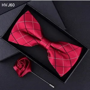 Detailed close-up of red plaid bow tie and rose lapel pin set inside a black gift box.