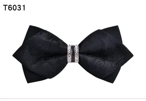 Close-up detail of black fabric bow tie featuring sparkling crystal rhinestones center.