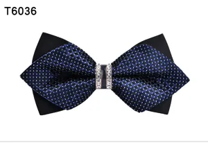 Detailed close-up of men's pointed bow tie with crystal center and black blue pattern.