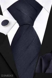 Detailed view of men's business navy blue tie, pocket square and cufflink set texture.