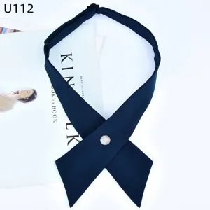 Dettaglio cravatta a croce blu scuro con bottone di perla per uniforme JK e accessori eleganti.