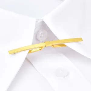 Épingle de col de chemise dorée gros plan, détail d'accessoire vestimentaire minimaliste.