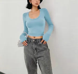 Close-up detail of stylish light blue long sleeve crop top, soft fabric and slim fit design.