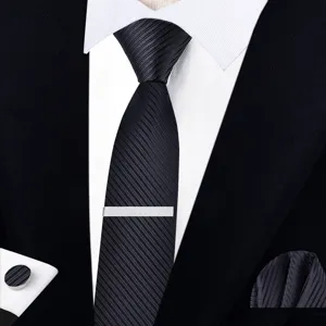 Gros plan détaillé d'une cravate noire classique à rayures pour homme avec pince et boutons.