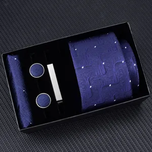Blue tie gift set detail showcasing geometric patterned fabric, matching pocket square, and cufflinks.
