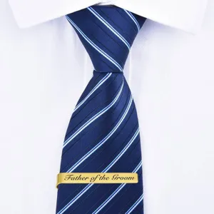 Gold stainless steel tie clip with custom Father of the Groom engraving and blue striped tie.