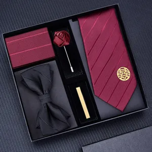 Closeup detail of wedding burgundy red tie, black bow tie, pocket square, and tie clip set.