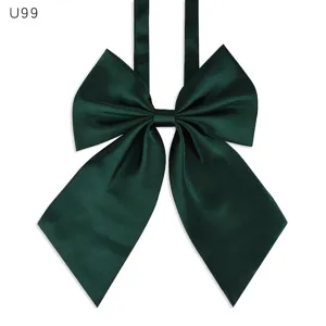 Primer plano de pajarita de satén verde oscuro, textura de tela detallada, accesorio de uniforme.