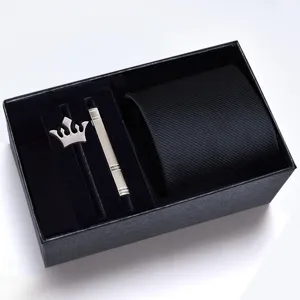 Detailed showcase of mens formal black tie set with crown brooch and tie clip in gift box