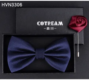 Close up detail of men dark blue textured bow tie and burgundy rose brooch gift box set.