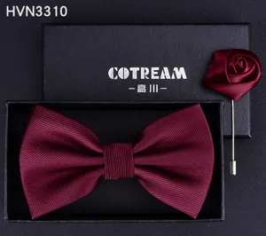 Burgundy bow tie and rose lapel pin detail shot, elegant satin fabric for formal suit wear.