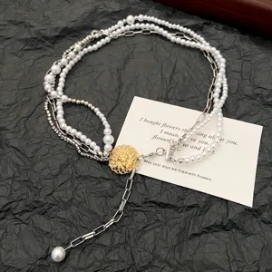 Detailed shot of multi-layer pearl necklace with vintage gothic pendant and metal chains.