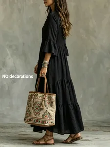 Detailansicht des eleganten schwarzen Langarm-Kleides mit V-Ausschnitt und Ethno-Tasche.