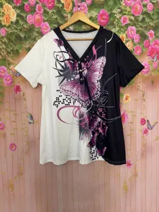 Vista detallada de una camiseta de manga corta en blanco y negro con estampado de mariposa y botones.