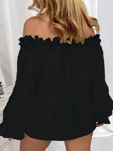 Dettaglio top nero a maniche lunghe con spalle scoperte e raffinata finitura con volant.