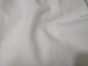 Close-up detail view of white ribbed fabric texture, soft elastic knit material.