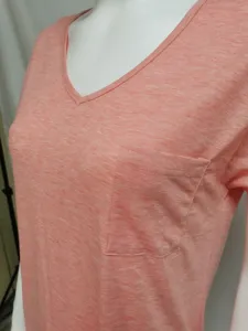 Primer plano detalle de camiseta mujer cuello V manga corta con bolsillo en rosa