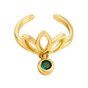 Detaillierte Nahaufnahme des goldenen Lotus-Zehenrings mit edlem grünem Smaragd-Anhänger.