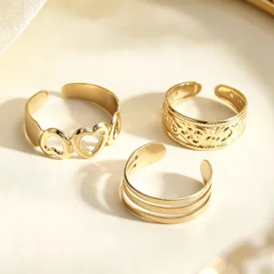 Set aus drei goldenen verstellbaren Zehenringen mit Herz-Aussparung und Mustern.