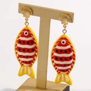 Boucles d'oreilles poisson tropical en résine avec rayures rouges et blanches. Élégant détail.