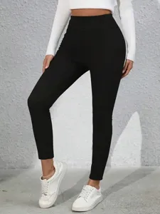 Vista dettagliata di leggings neri a vita alta da donna, che mostrano vestibilità e tessuto.