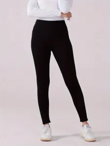 Vista dettagliata di leggings termici neri a vita alta abbinati a un top bianco.