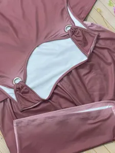 Completo top smanicato e pantaloncini rosa antico con dettagli di anello in metallo.