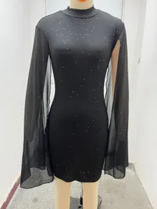 Vista detallada del vestido negro brillante con cuello alto y mangas de capa