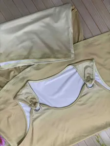 Dettaglio set sfumato con top smanicato con anelli metallici e pantaloncini coordinati.