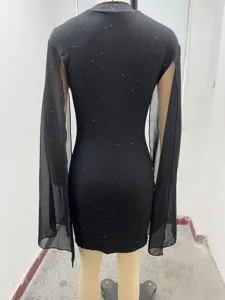 Vestido negro ajustado con cuello alto, mangas capa transparentes y detalles brillantes, detalle.