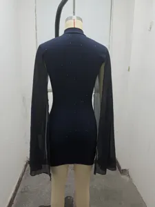 Vestido ajustado azul oscuro con cuello alto, mangas de capa transparentes y detalles brillantes.