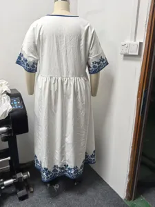 Back view detail of white loose casual midi dress with blue floral print sleeves and hem.