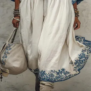 Close-up detail shot of bohemian style long dress with blue floral hem print and accessories.