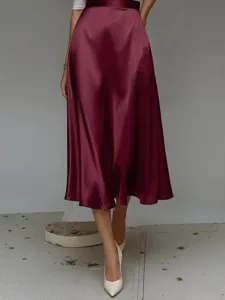 Detail shot of a burgundy satin A-line midi skirt featuring smooth fabric and elegant flow.
