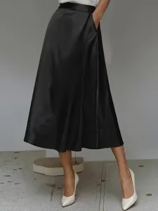 Close-up of the elegant black satin midi skirt showing smooth fabric texture and A-line drape.