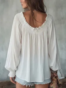 Back detail view of a white long-sleeve blouse with ruffled collar and boho aesthetic.