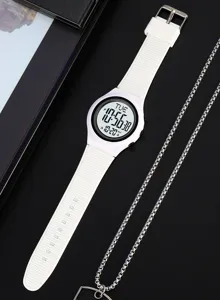 White silicone digital sports watch detail shot with clear electronic screen and dark background